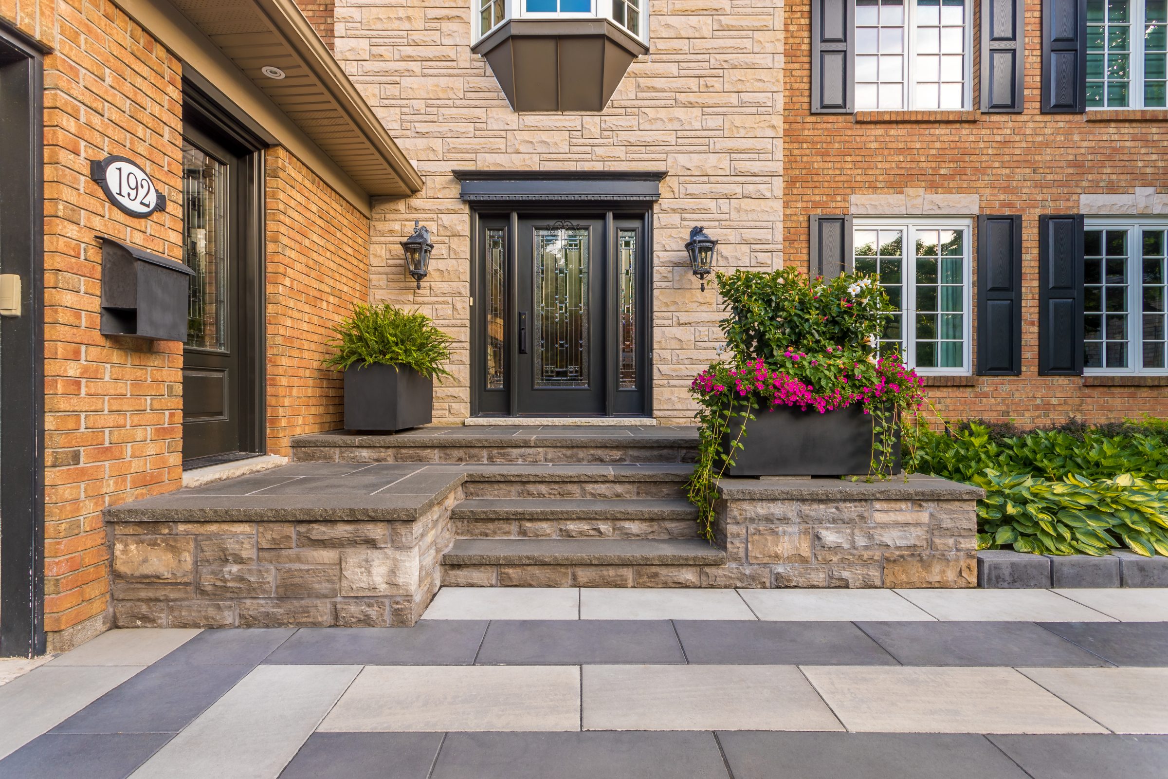 Modern brick house entrance with potted plants