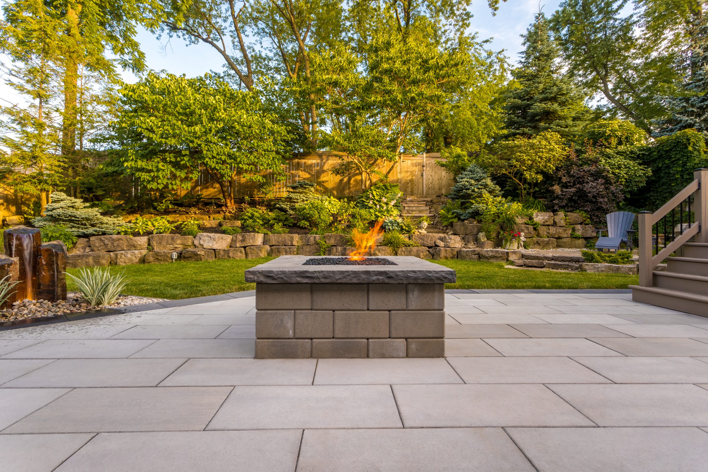 Backyard fire pit with stone patio and landscaping.