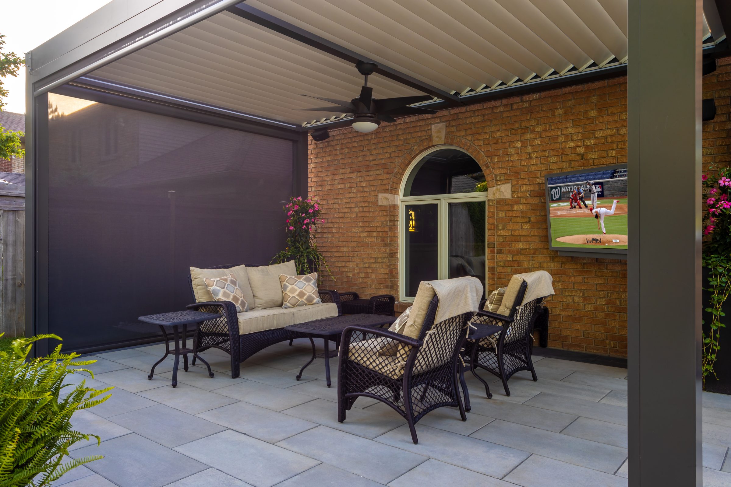 Covered patio with seating and outdoor TV.