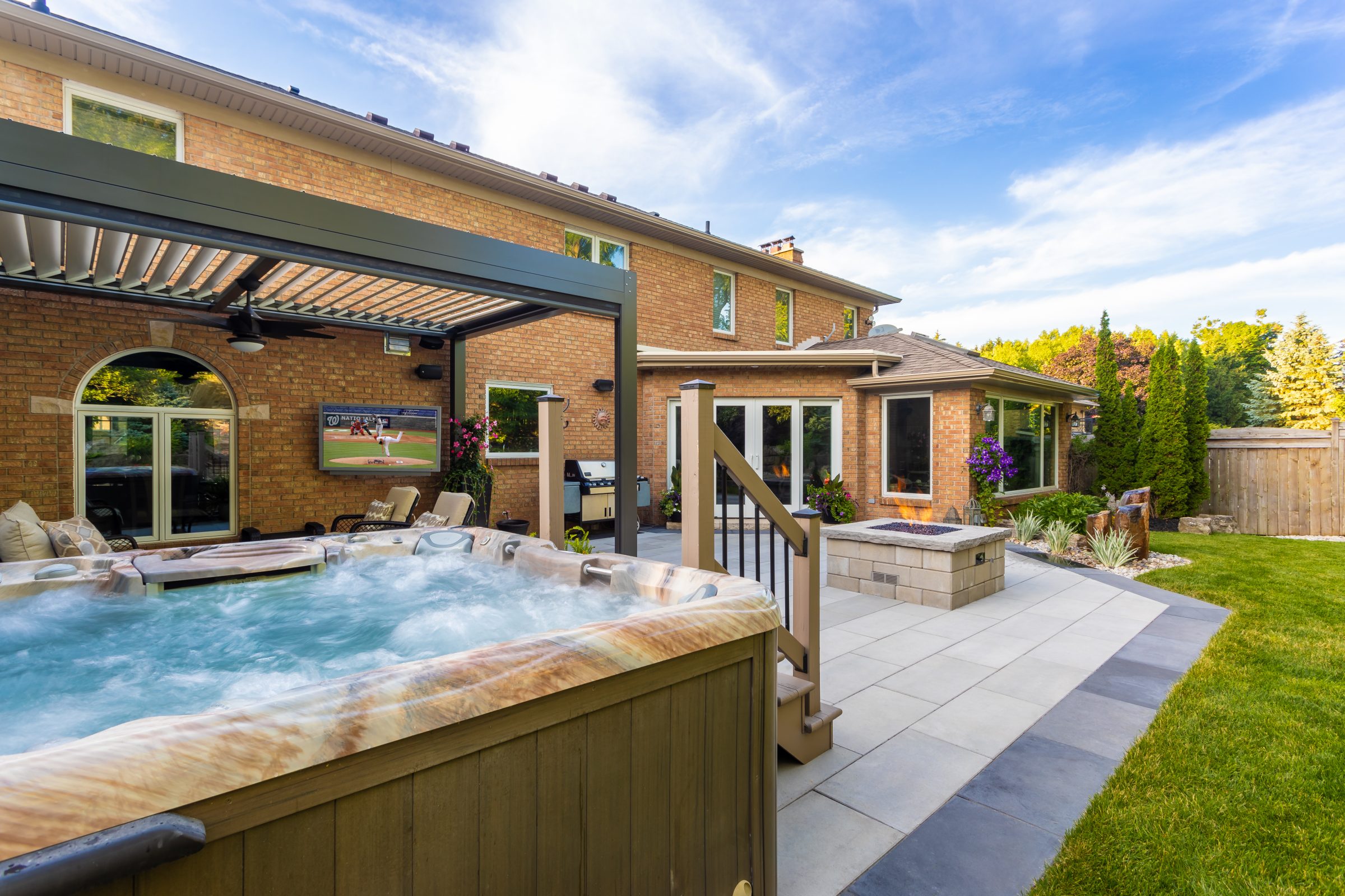 Outdoor patio with hot tub and lush garden