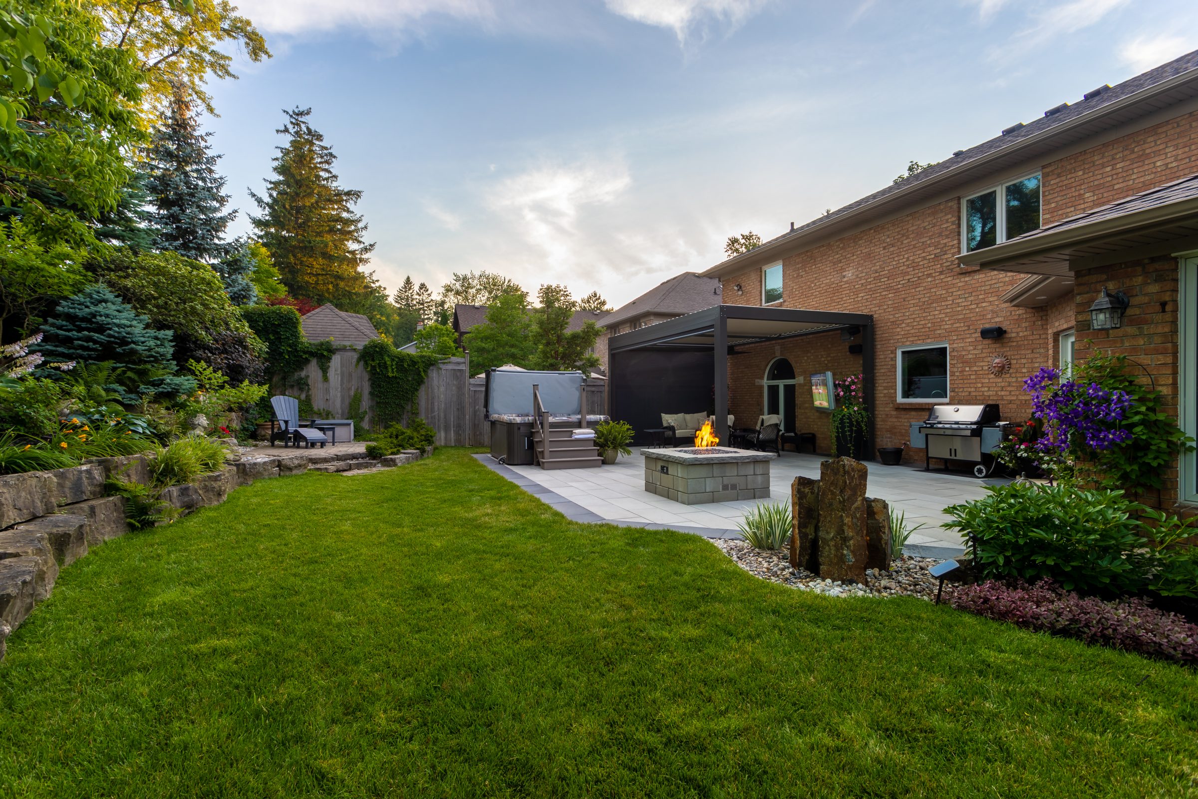 Backyard with patio, fire pit, and lush garden.