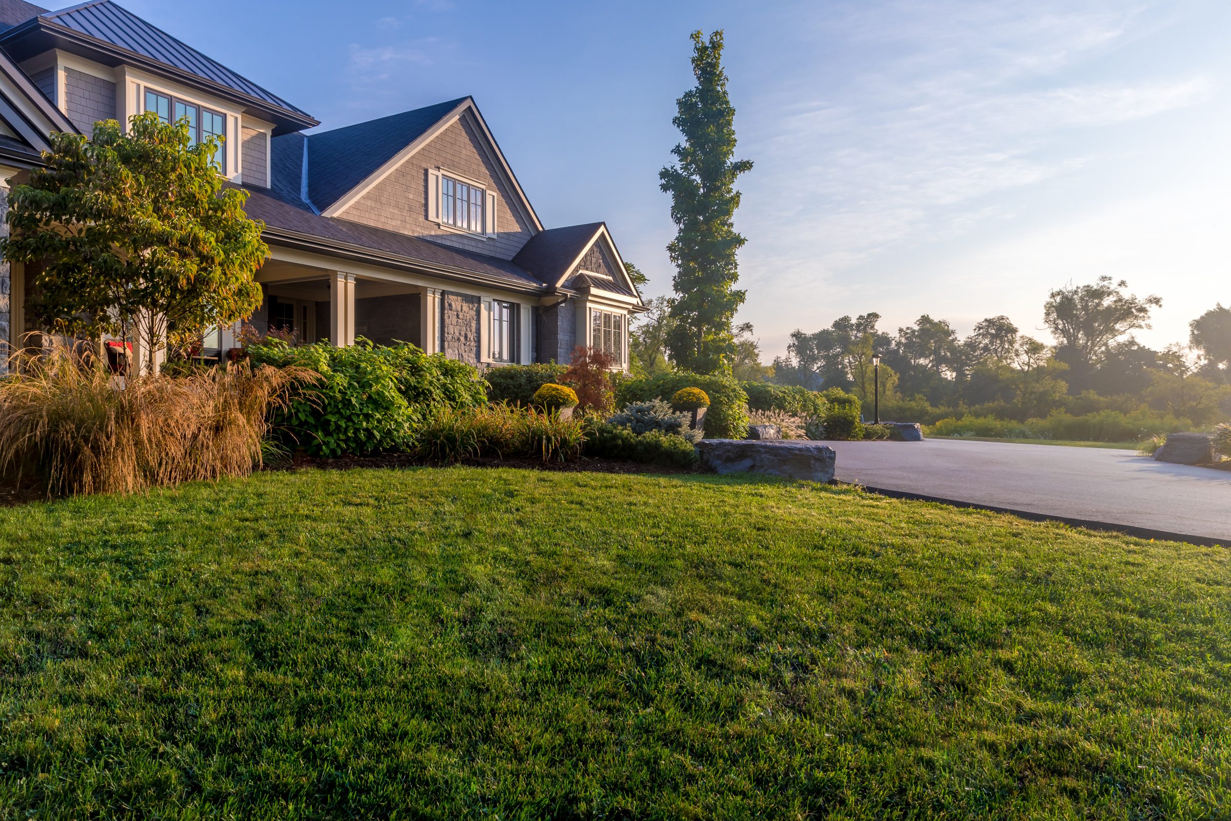 House with lush green lawn at sunrise