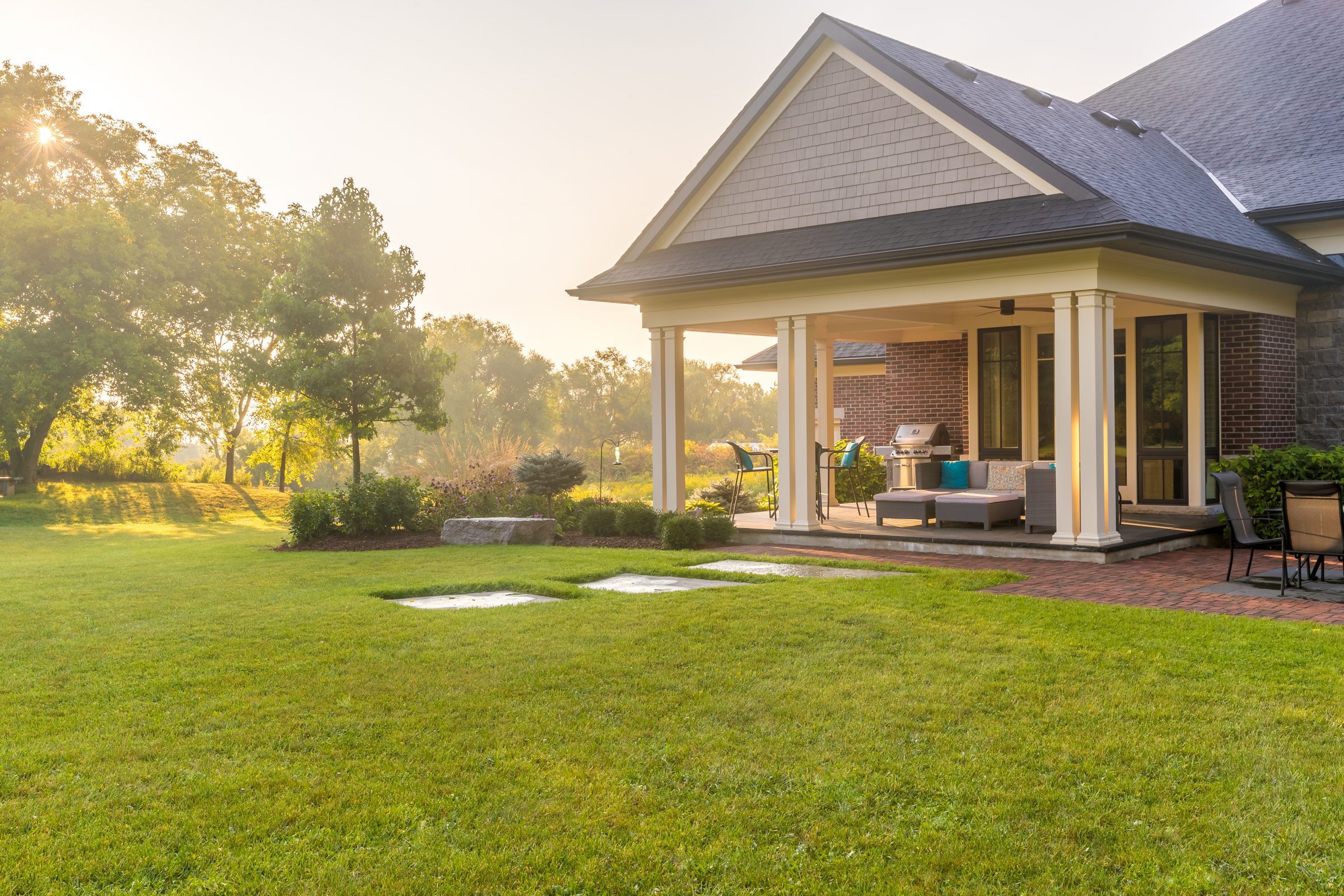 Sunny backyard with patio and lawn