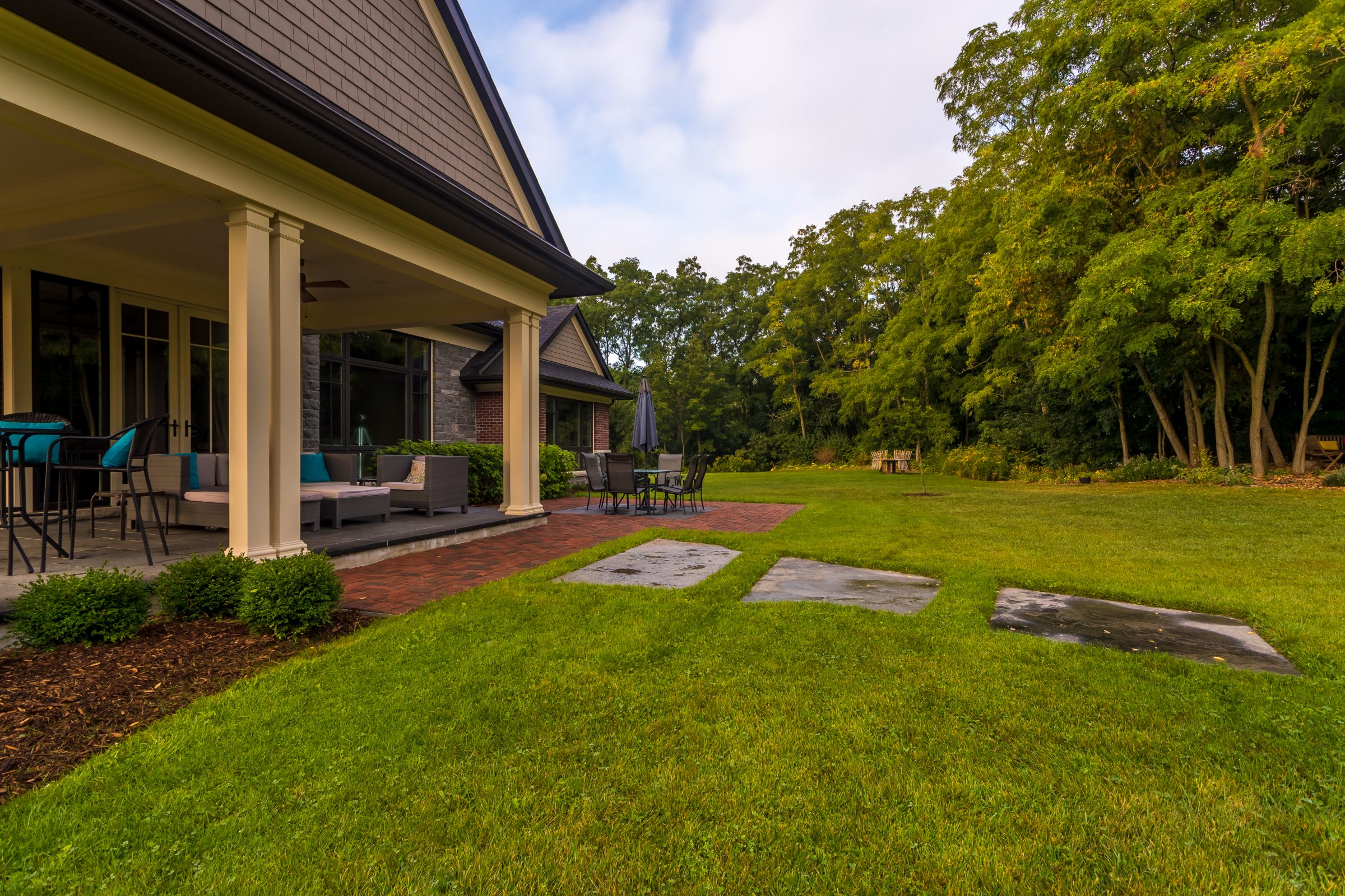 Spacious backyard with patio and outdoor furniture.