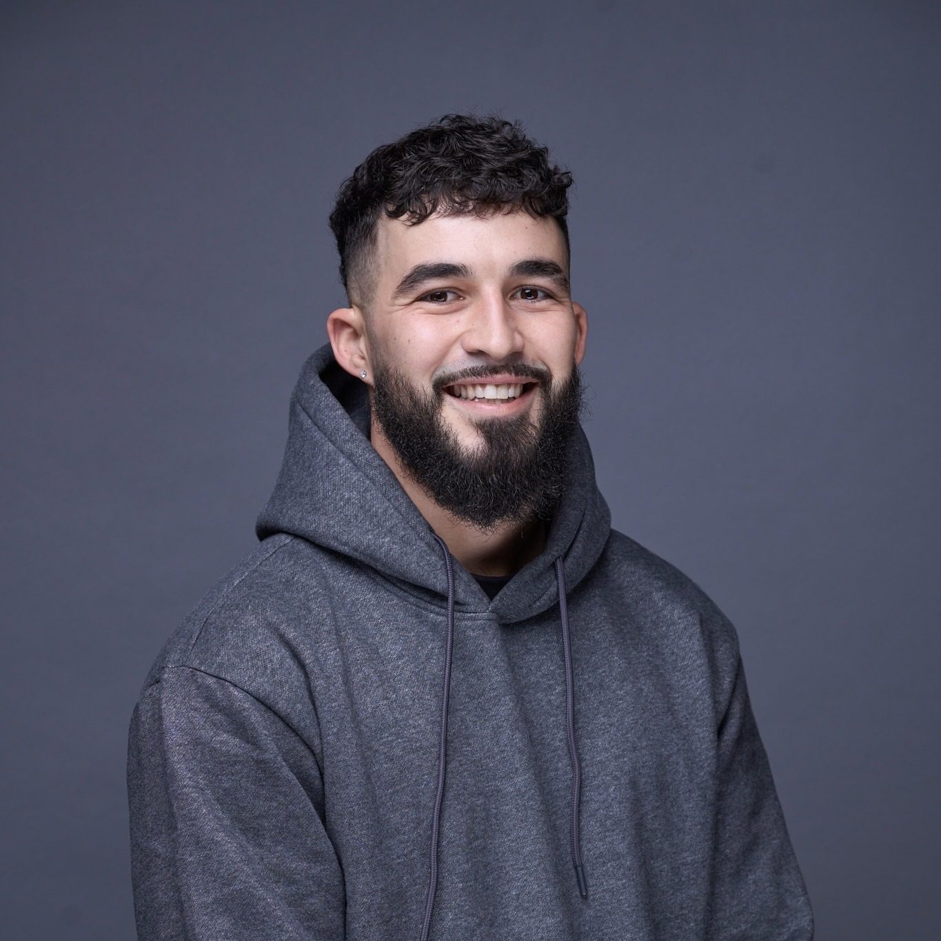 Smiling man in gray hoodie