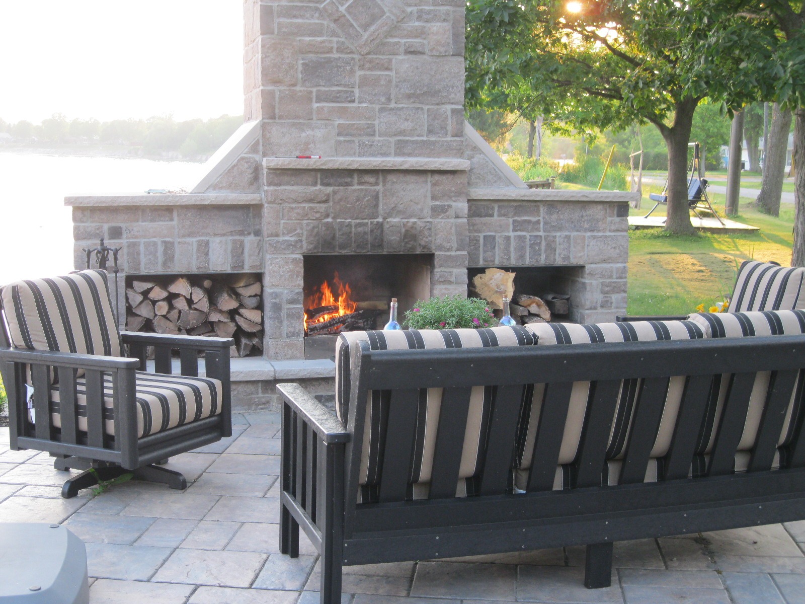 Outdoor patio with fireplace and striped furniture.