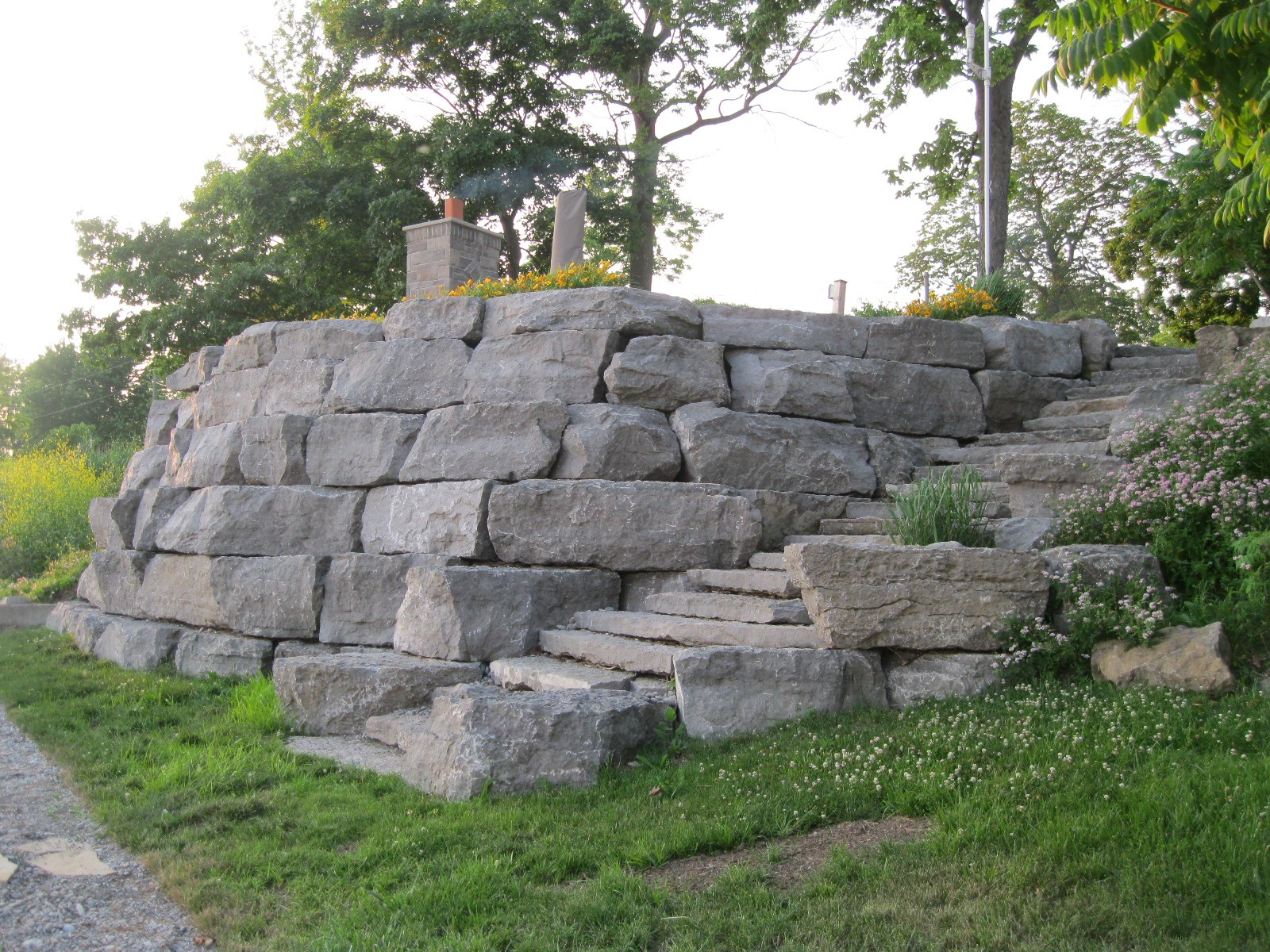 Stone retaining wall with stairs and greenery