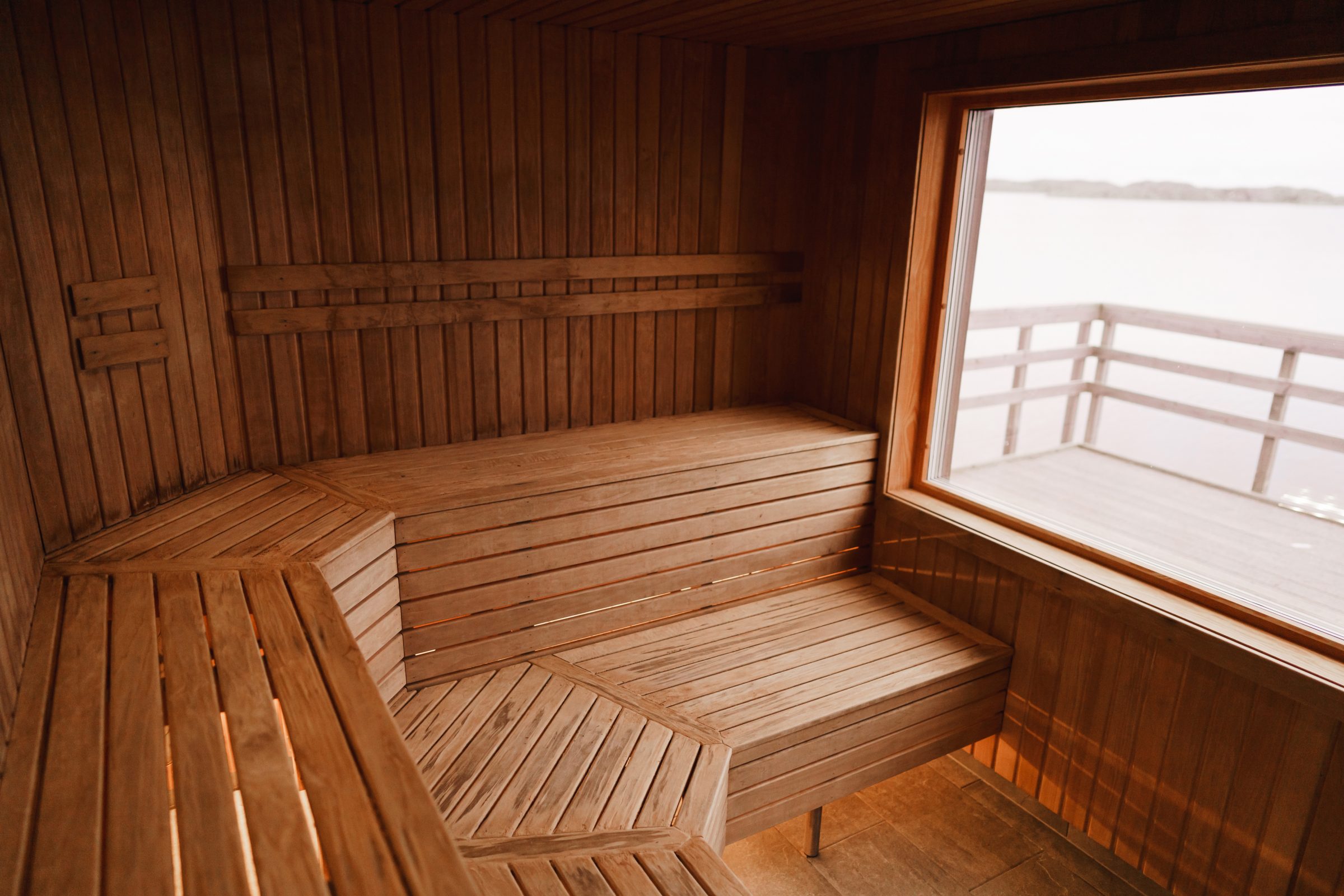 Wooden sauna interior with large window view.