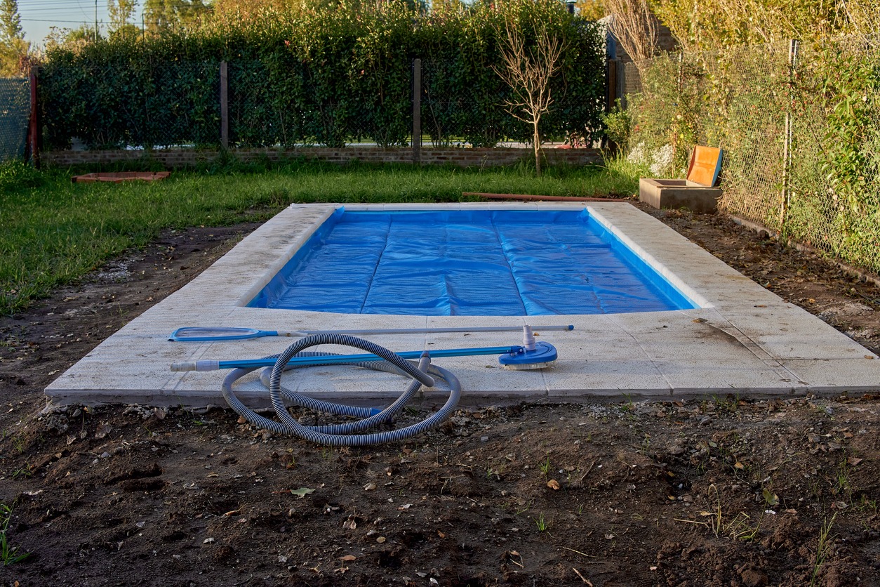 Backyard swimming pool with cleaning equipment.