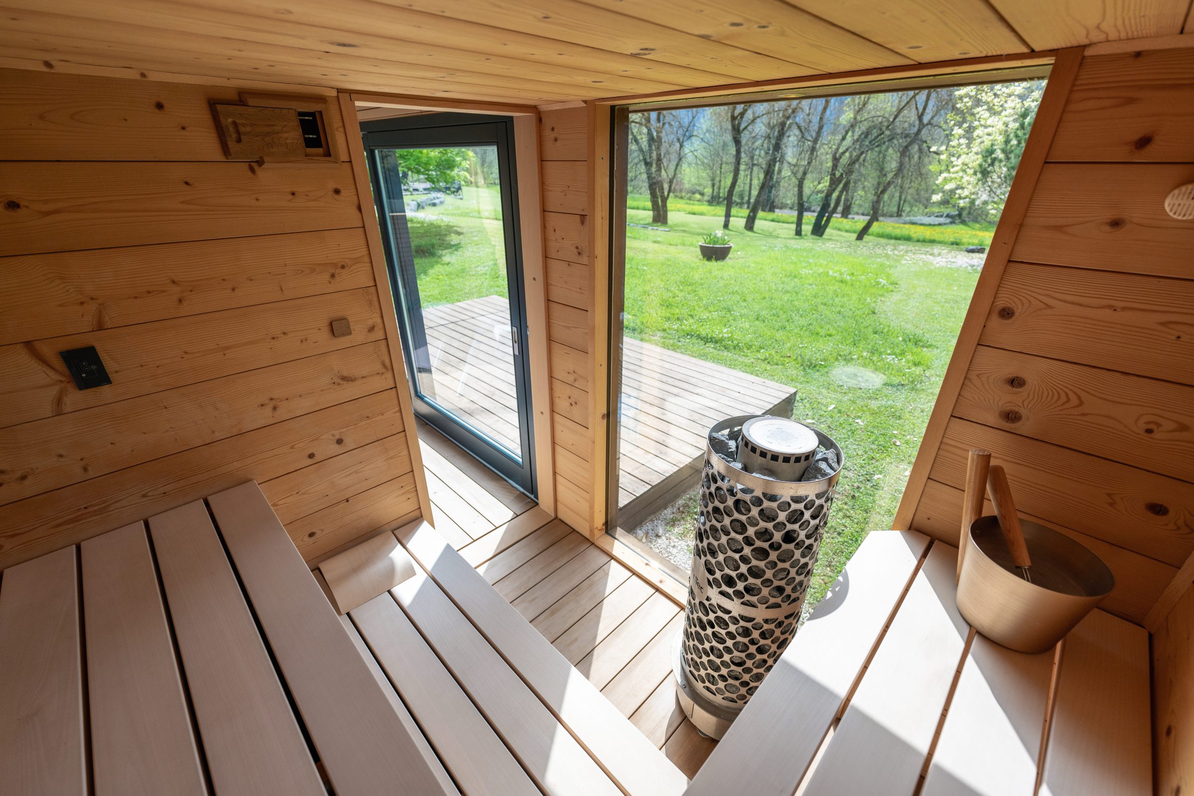 Wooden sauna interior with garden view.