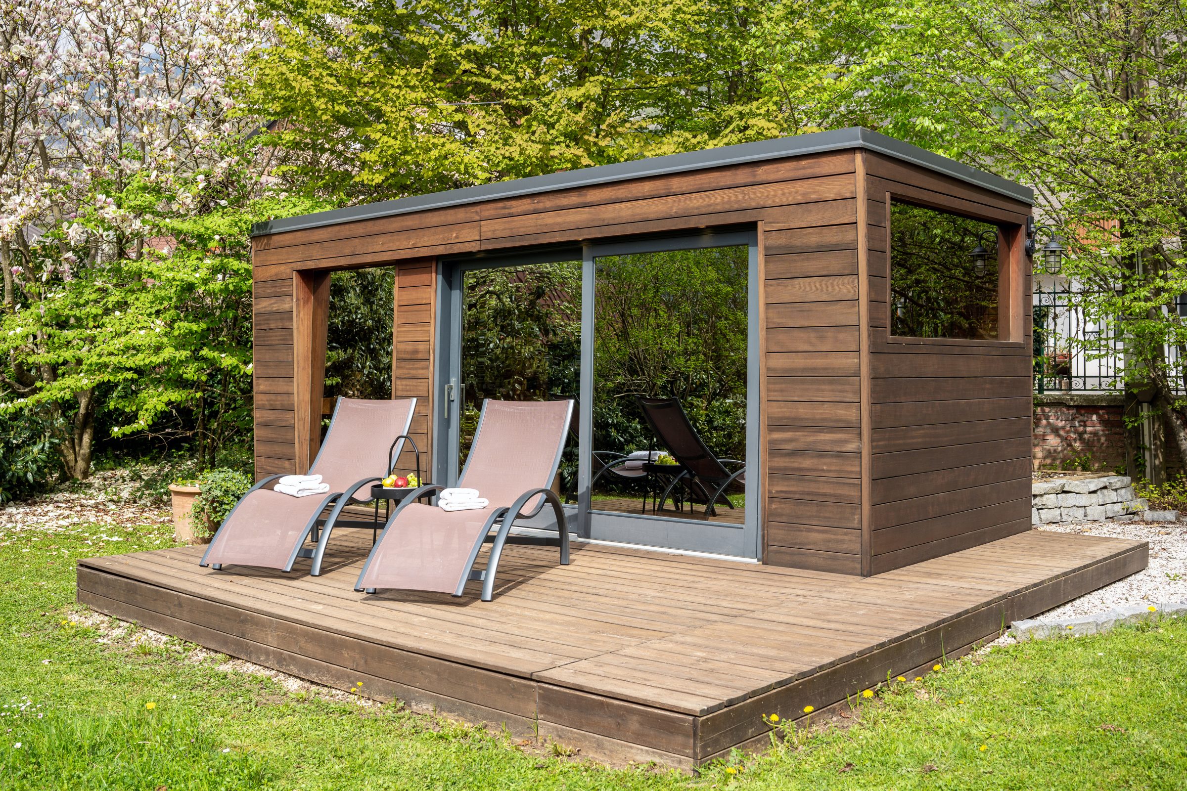 Wooden garden shed with loungers on deck