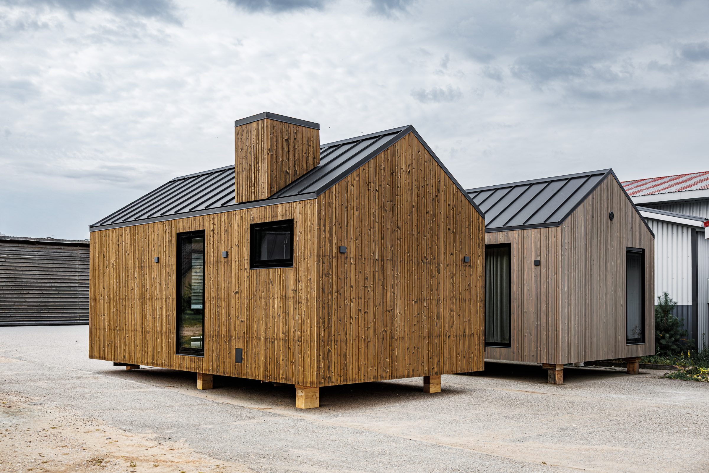 Modern wooden modular homes on concrete surface.